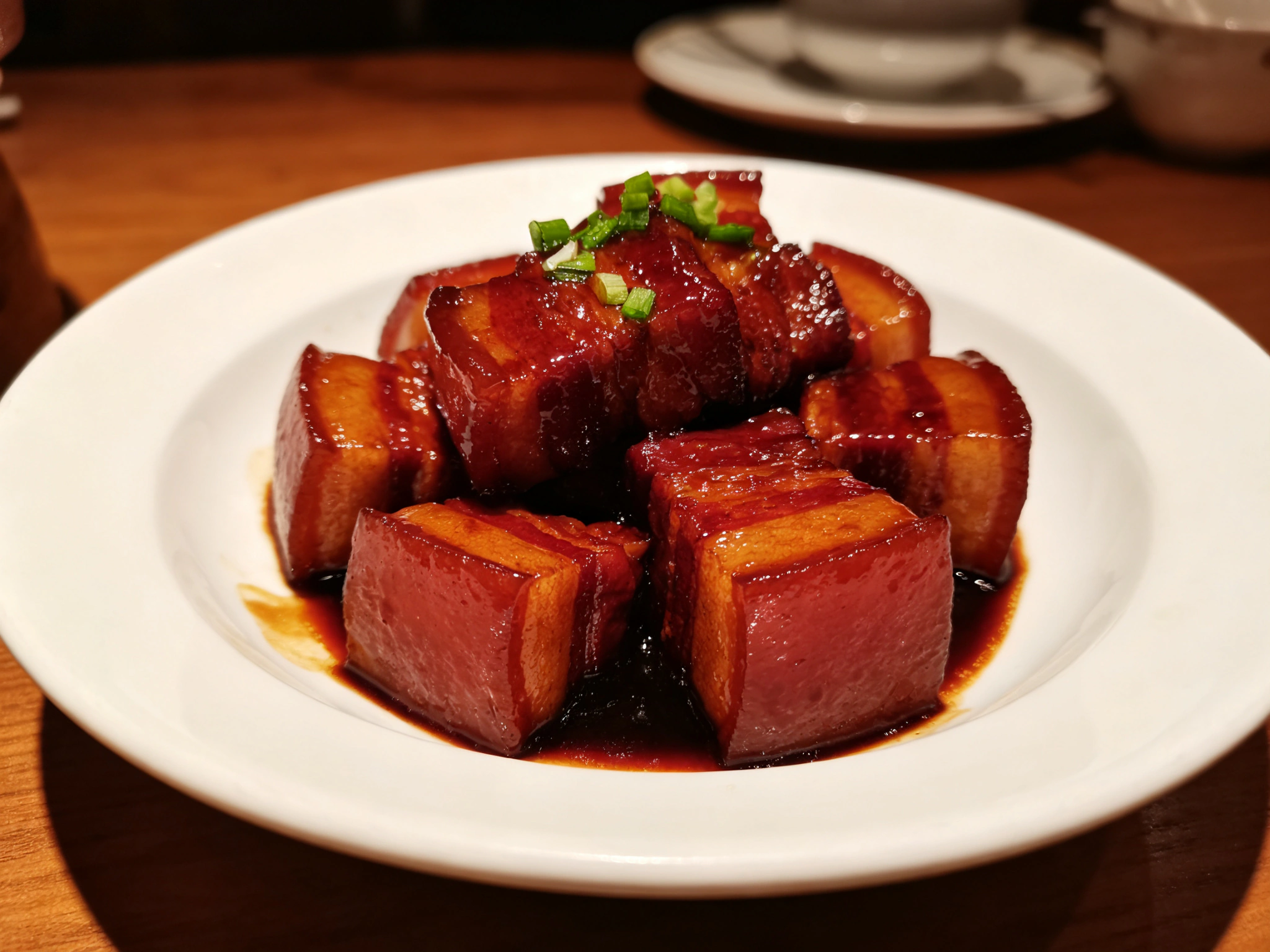 A plate of glossy red-braised pork belly